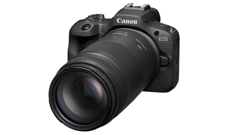 A black Canon EOS digital camera with a large detachable zoom lens attached, viewed from a front angled perspective against a white background.