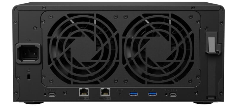 Rear view of a network-attached storage (NAS) device showing two large cooling fans, an AC power input, two Ethernet ports, two USB 3.0 ports, an expansion slot, and a lock slot.