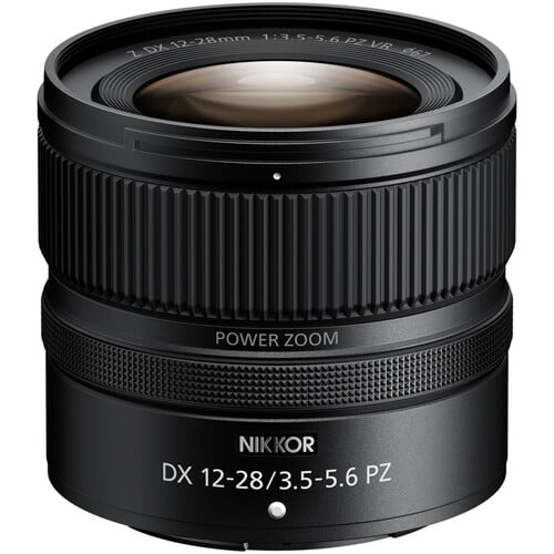 A black Nikon NIKKOR DX 12-28mm f/3.5-5.6 PZ VR camera lens with power zoom, featuring textured focus and zoom rings, standing upright on a white background.