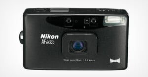 A black Nikon AF600 compact film camera with a built-in flash, viewfinder, and lens labeled “Nikon Lens 28mm 1:3.5 Macro.” The “Panorama” logo appears in the lower right corner.