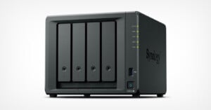 A black Synology network-attached storage (NAS) device with four drive bays, status indicator lights, a USB port, and a power button on the front panel, shown against a plain white background.