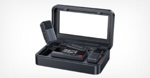 A portable Saramonic wireless microphone system in a black charging case, including a transmitter, receiver, and microphone components, with the case lid open and an empty display area inside the lid.