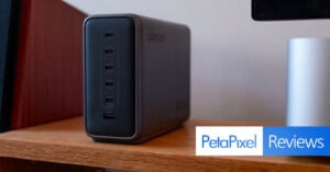 A UGREEN charging station with multiple USB-C and one USB-A port sits on a wooden shelf. The Petapixel Reviews logo appears in the bottom right corner.